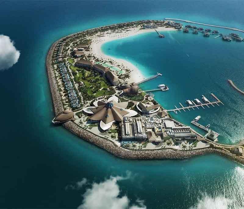 Tropical setting at Banana Island Resort with overwater villas, palm trees, and turquoise sea under the sun.