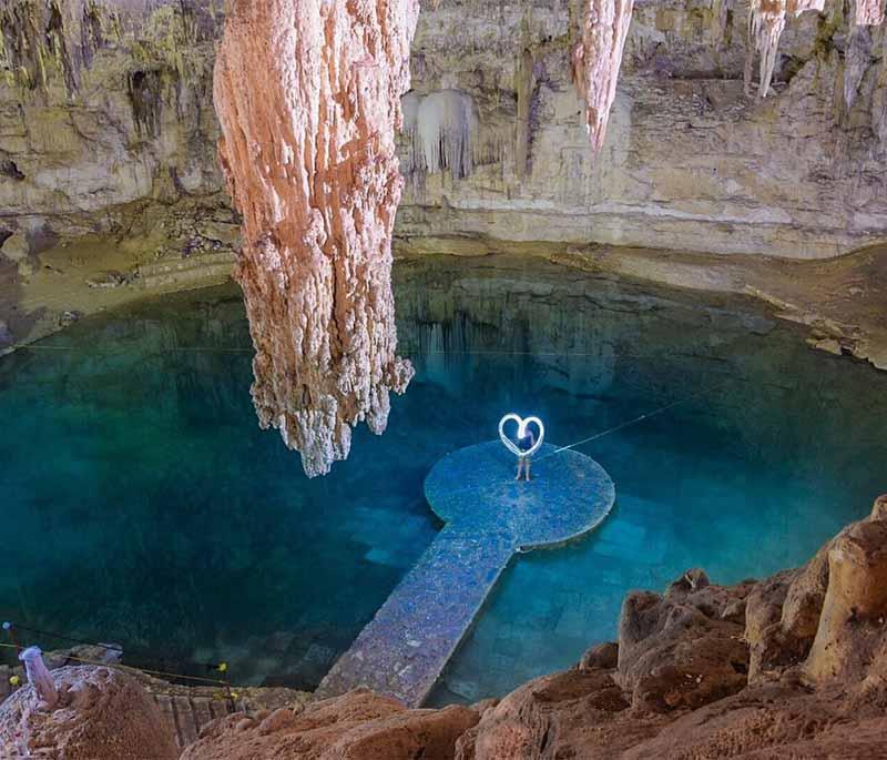 Cenote Suytun, Yucatan - Iconic central platform creates mesmerizing reflection, popular for photographs.