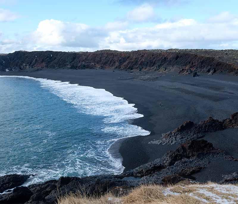 Djúpalónssandur Beach, a black sand beach on the Snaefellsnes Peninsula with unique rock formations and shipwreck remains.