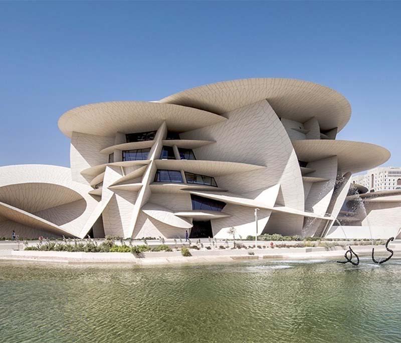 Exterior of the Doha Museum of Modern Art with geometric design, water features, and minimalist landscaping.