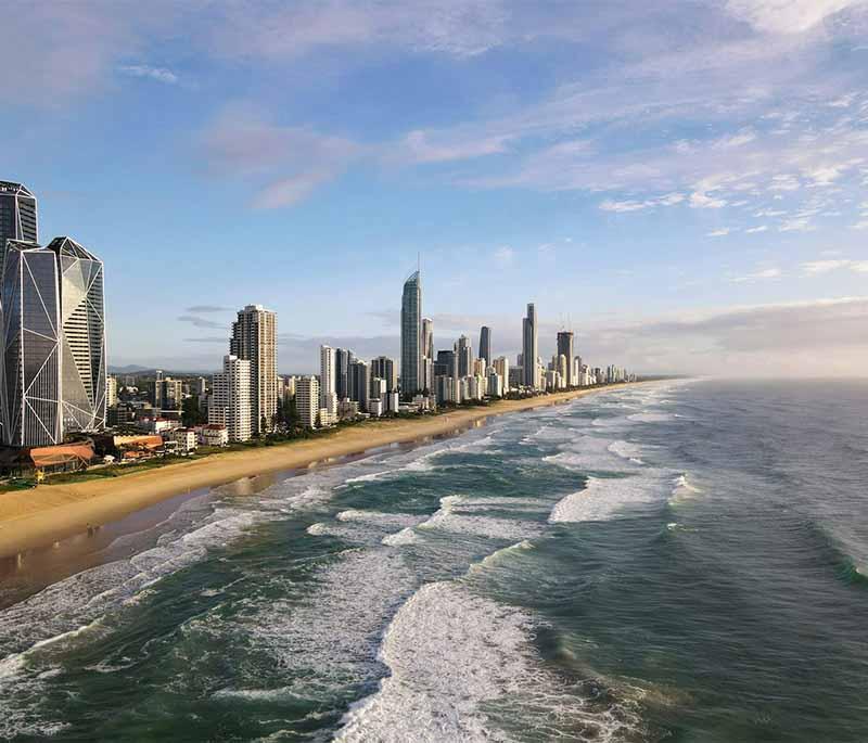 Gold Coast in Queensland is famous for its lively atmosphere, theme parks, long sandy beaches, and vibrant nightlife.