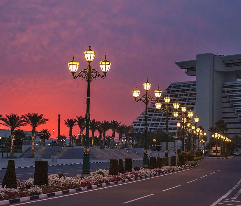 Busy Grand Hamad Street with banks, commercial buildings, traffic, and people walking along wide sidewalks.