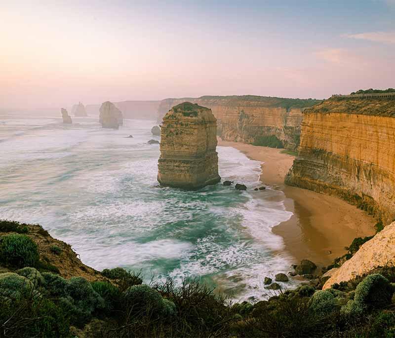 Great Ocean Road in Victoria features breathtaking coastal scenery and the famous Twelve Apostles rock formations.