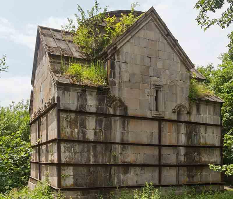 Jukhtakvank Monastery, presenting secluded medieval monastic ruins surrounded by dense forest and peaceful setting.