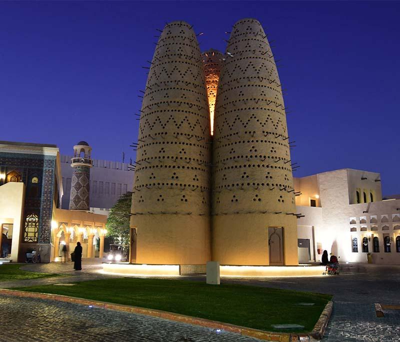 Courtyards and pathways at Katara Cultural Village, with art installations, traditional buildings, and visitors.
