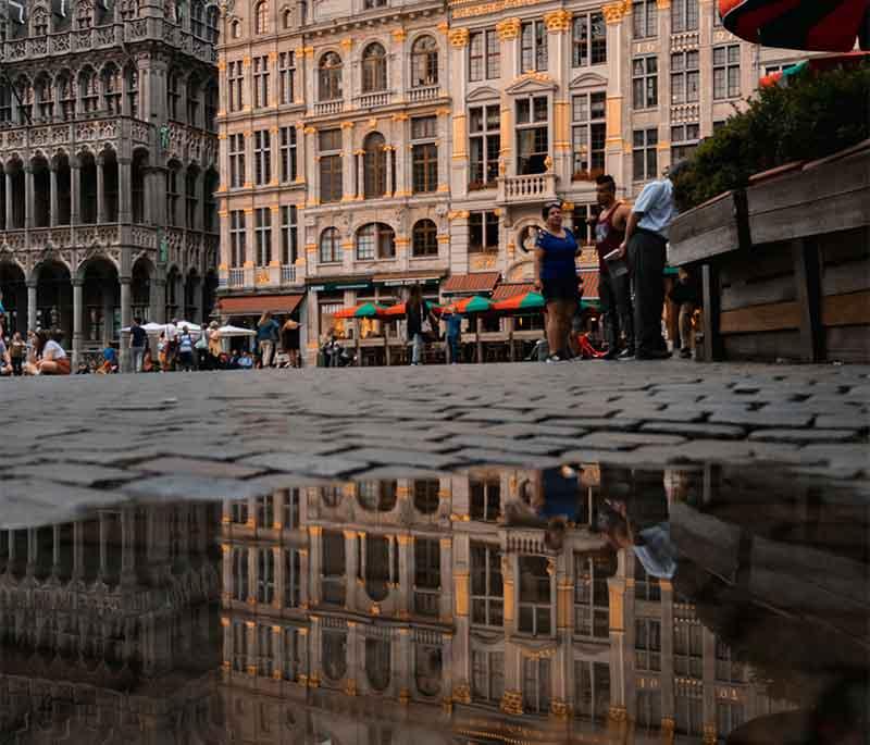 Mons' Grand Place, a central square with buildings, lively cafes, and the Town Hall, reflecting the city's rich history.