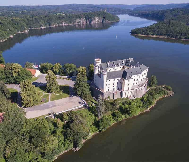 Orlik Castle, a stunning chateau above the Vltava River, featuring elegant interiors and beautiful surroundings.