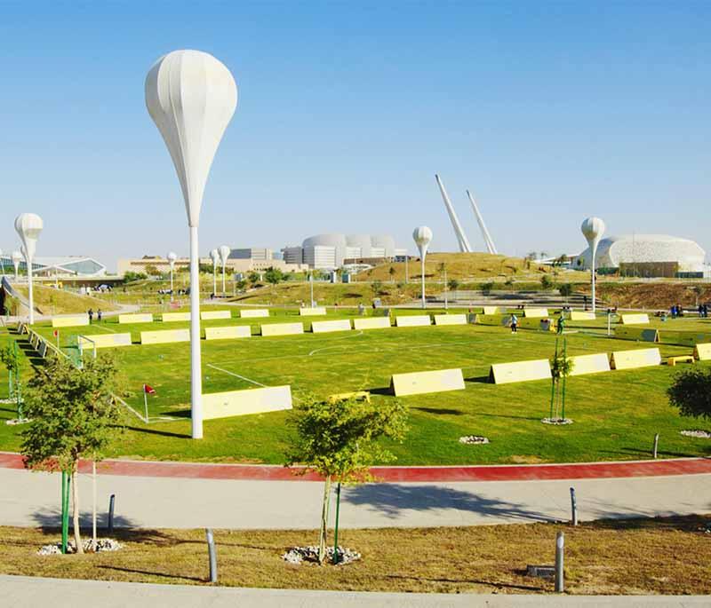 Oxygen Park’s green lawns, misting arches, and joggers enjoying a shaded trail in the heart of Education City.