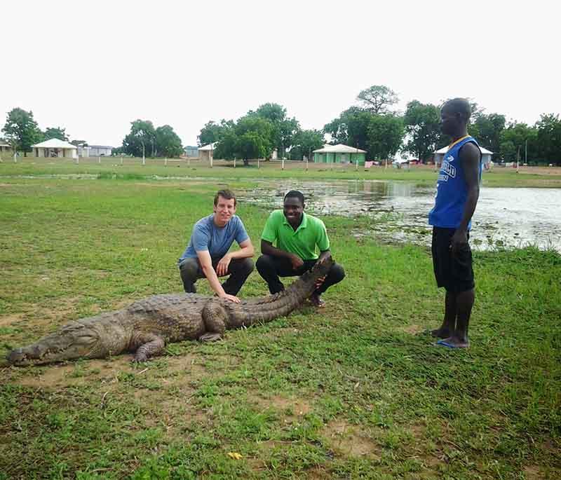 Paga Crocodile Pond, a sacred site where visitors can get up close to friendly crocodiles, guided by local caretakers.