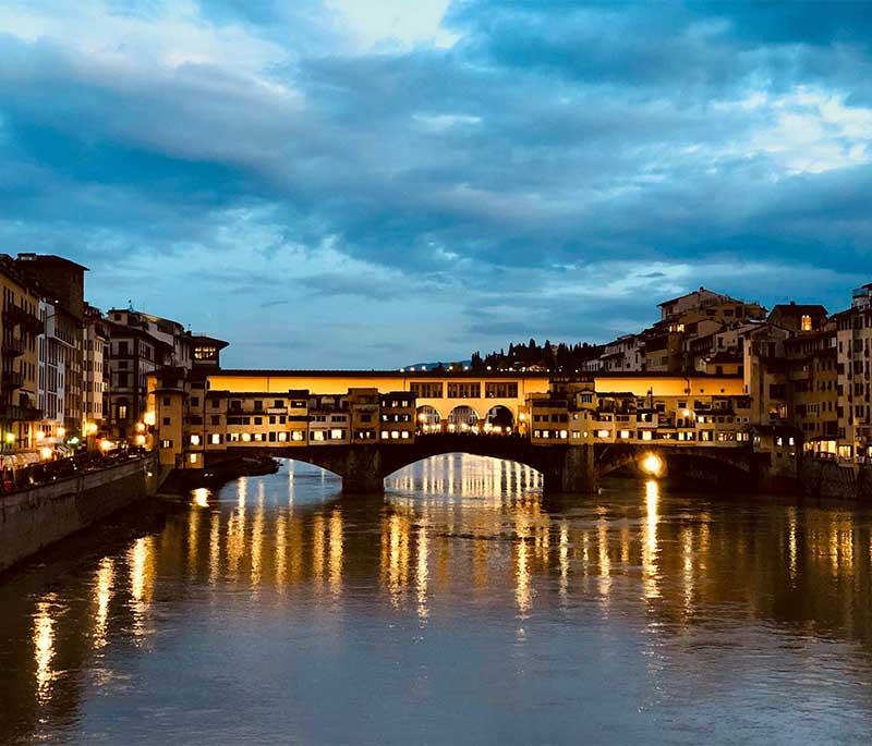 Ponte Vecchio, Florence, a medieval stone bridge over the Arno River, lined with shops and known for its picturesque views.