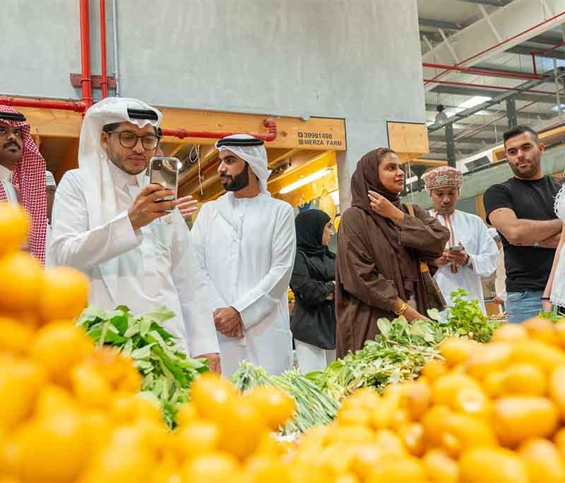 Qalali Farmers' Market, showcasing local produce, goods, and vibrant community market setting with lively atmosphere.