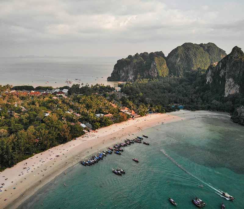 Railay Beach, Krabi - Stunning beach surrounded by limestone cliffs, perfect for sunbathing and rock climbing.