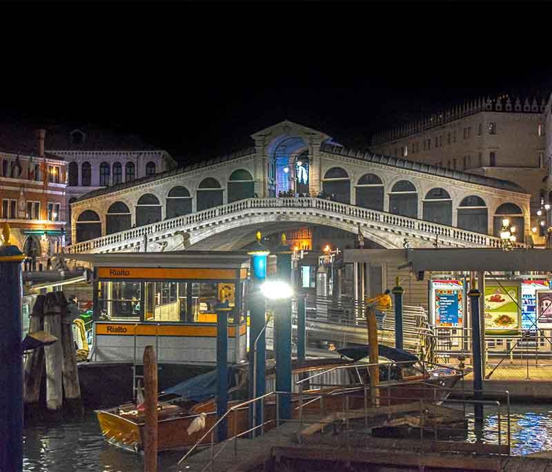 Rialto Bridge, Venice, a historic stone bridge spanning the Grand Canal, known for its shops and stunning views.