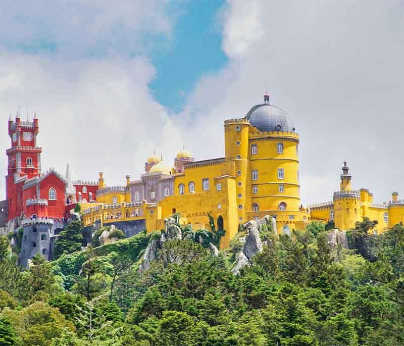 Sintra - A picturesque town near Lisbon, home to fairy-tale palaces like the Pena Palace and lush gardens, a UNESCO site.