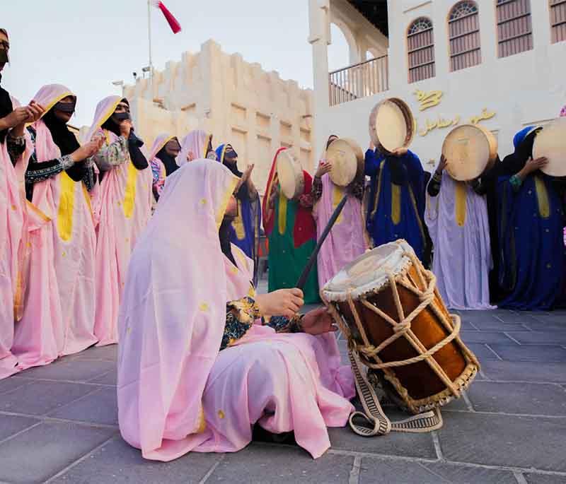 Souq Waqif’s lively scene with spice shops, traditional garments, street food, and tourists mingling.