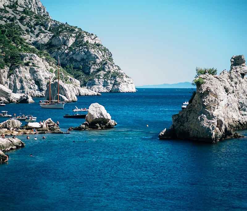 The Calanques, Marseille, stunning limestone cliffs and bays offering hiking, boating, and views of the Mediterranean.