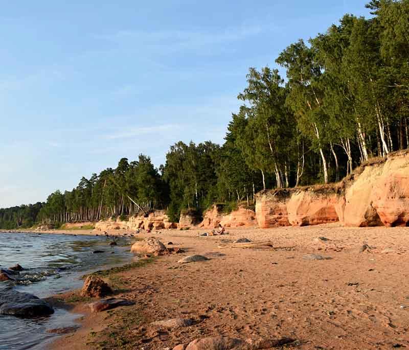 Veczemju Cliffs, striking red sandstone cliffs along the Vidzeme coast, offering beautiful views and a scenic hiking trail.